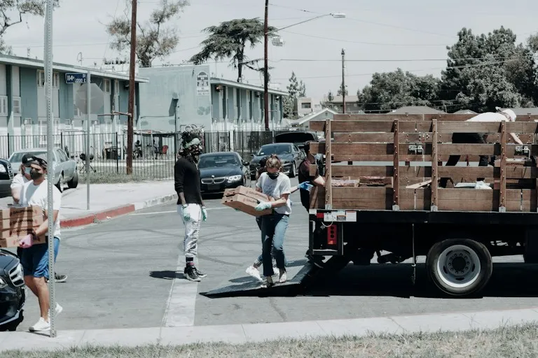 Volunteers in masks unloading boxes from a truck
